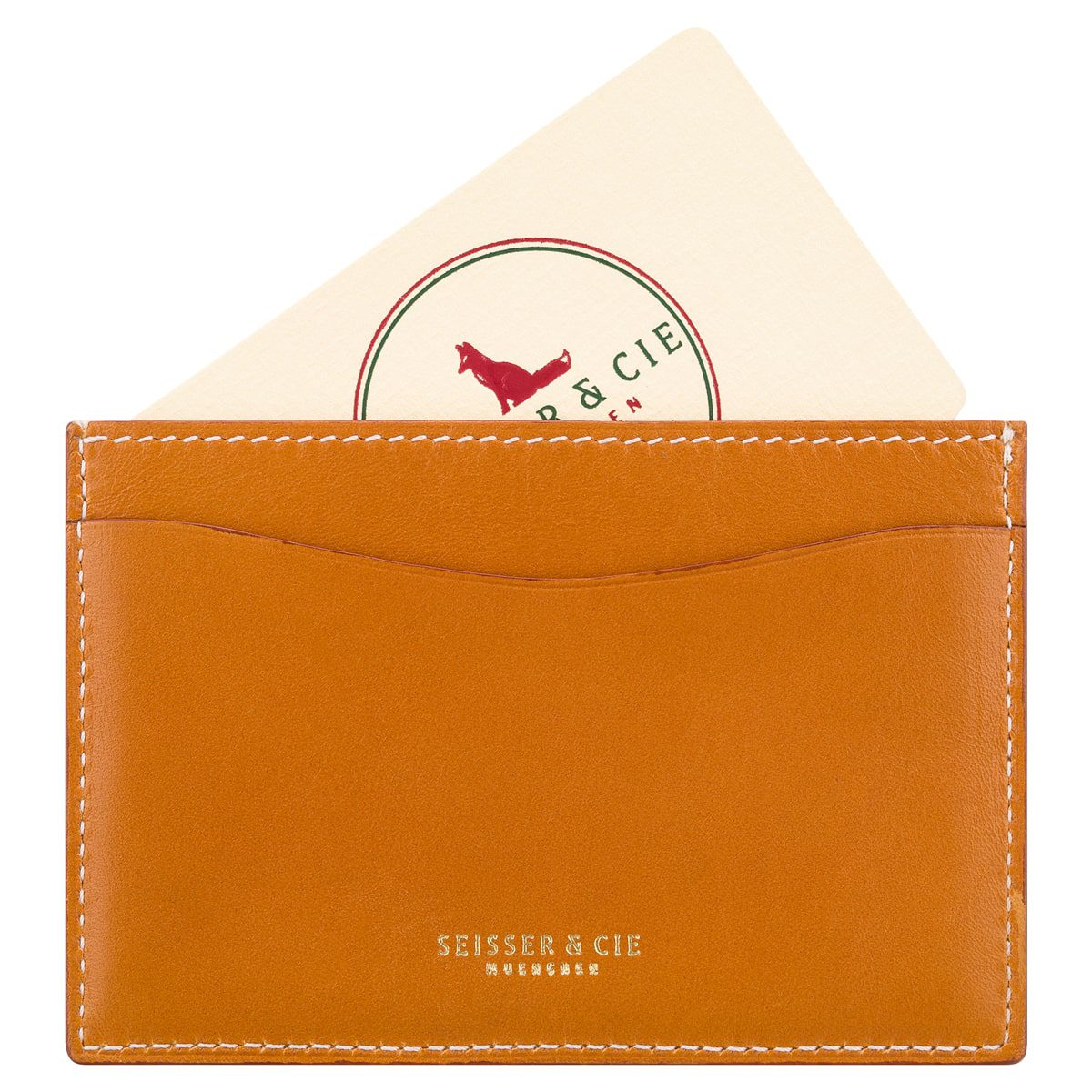 Das Kreditkarten-Etui (Racing Green) enthält eine cremefarbene Karte mit einem roten Fuchs und grünem Text. Weiße Nähte akzentuieren das hellbraune Leder, und "SEISSER & CIE MÜNCHEN" ist in Gold auf den Kartenhalter gedruckt.