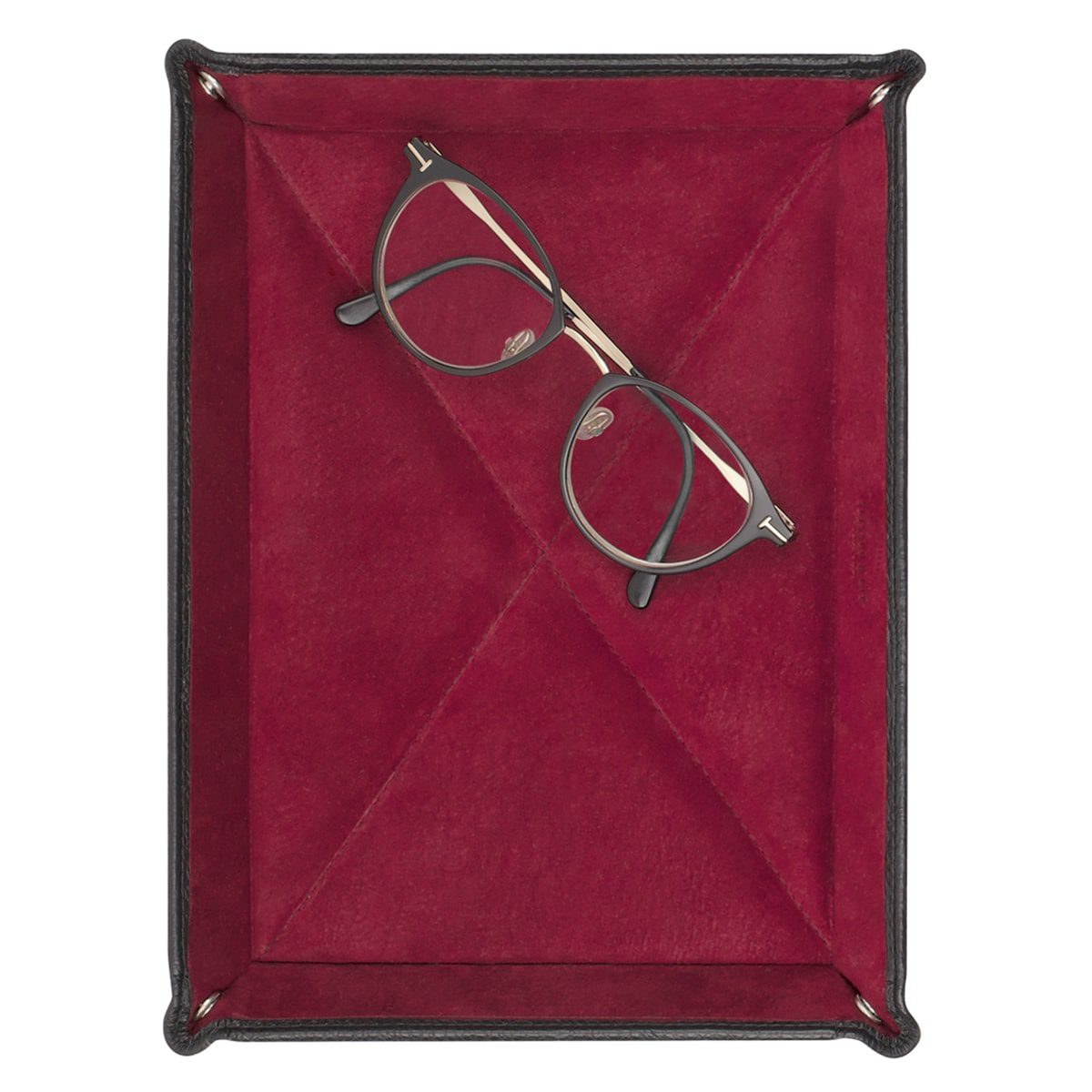 Eine runde, dunkel gerahmte Brille liegt schräg in einer Vide-Poche L (21x15cm), einem rechteckigen Tablett mit rotem Samtfutter und schwarzen Lederrändern, wie von oben gesehen.