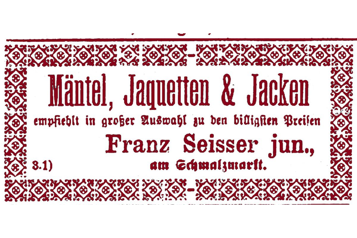 Eine alte deutsche Anzeige mit dekorativem rotem Rand, die für Mäntel, Jacken und Blazer wirbt, die von Franz Seisser jun. zu günstigen Preisen angeboten werden. Der Text ist in einer altmodischen Schriftart gedruckt.