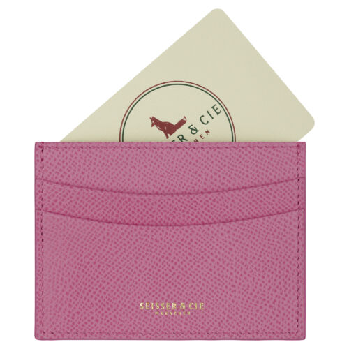 Ein rosa, strukturiertes Kreditkarten-Etui (Rosa) mit der goldenen Aufschrift "SEISSER & CIE MÜNCHEN" hält eine cremefarbene Karte mit rotem Fuchs-Logo und kreisförmigem Text.